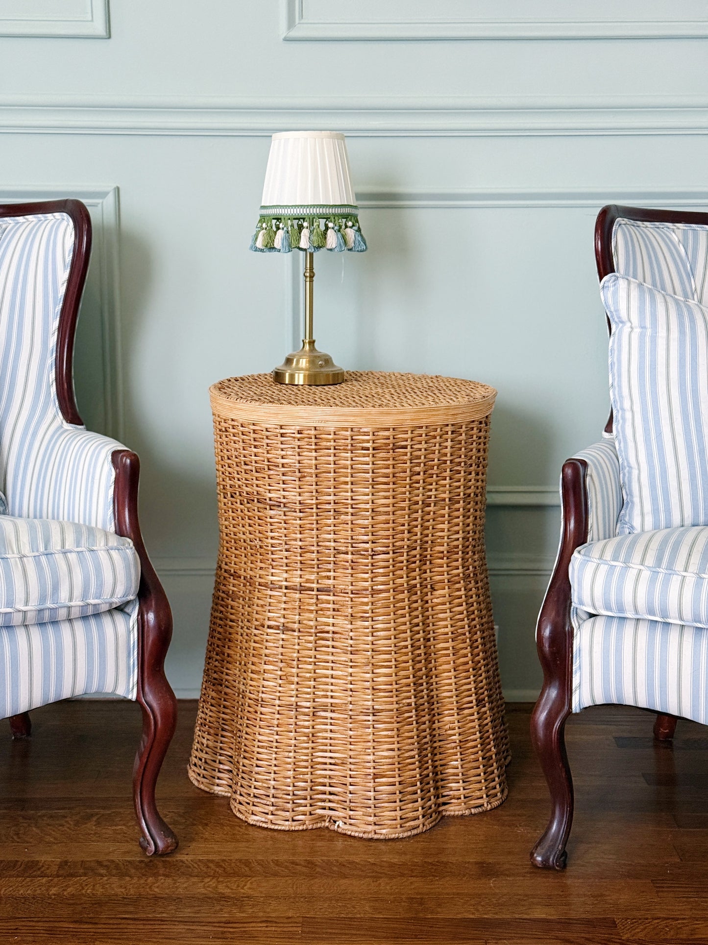 Scalloped wicker side table with antique chairs