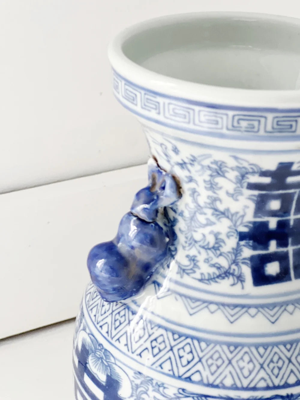beetle handle detailing on a blue and white double happiness vase