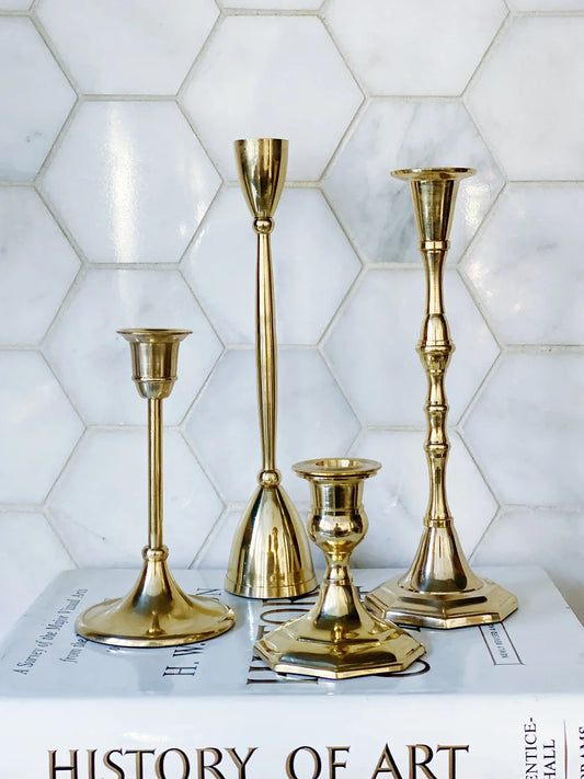 set of four mixed size gold candle stick holders