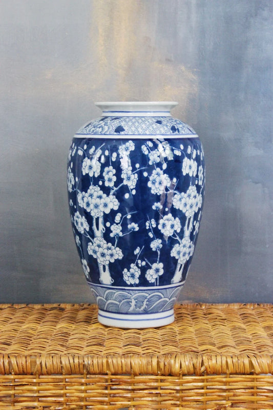 blue and white large plum blossom floral vase on a wicker pedestal