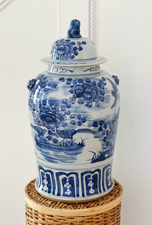 Large blue and white foo dog temple jar on a wicker pedestal