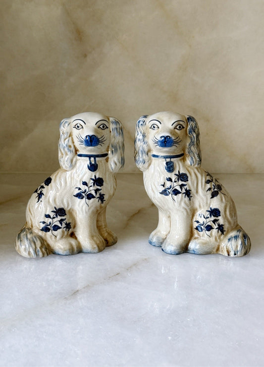 Pair of blue and white floral Staffordshire dogs facing forward against a neutral background
