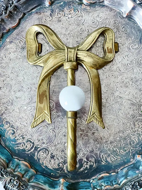 vintage brass bow wall hook with porcelain, on a vintage silver serving tray
