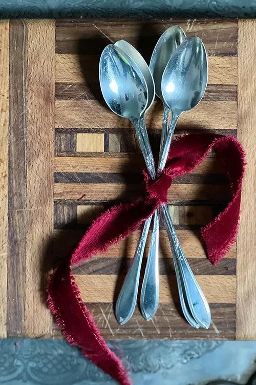 antique silver tea spoons wrapped in a red velvet bow