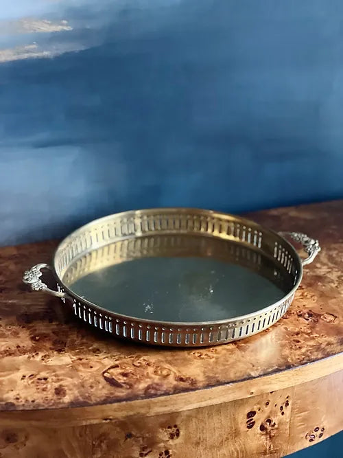 vinage brass serving tray on a burl wood table 