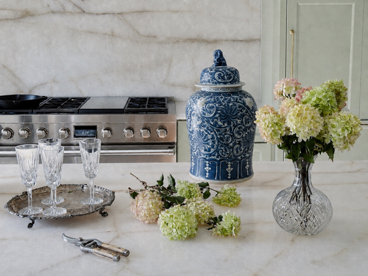 Kitchen island styled with limelight hydrangeas, blue and white ginger jar, vintage silver tray, and vintage Waterford crystal glasses.