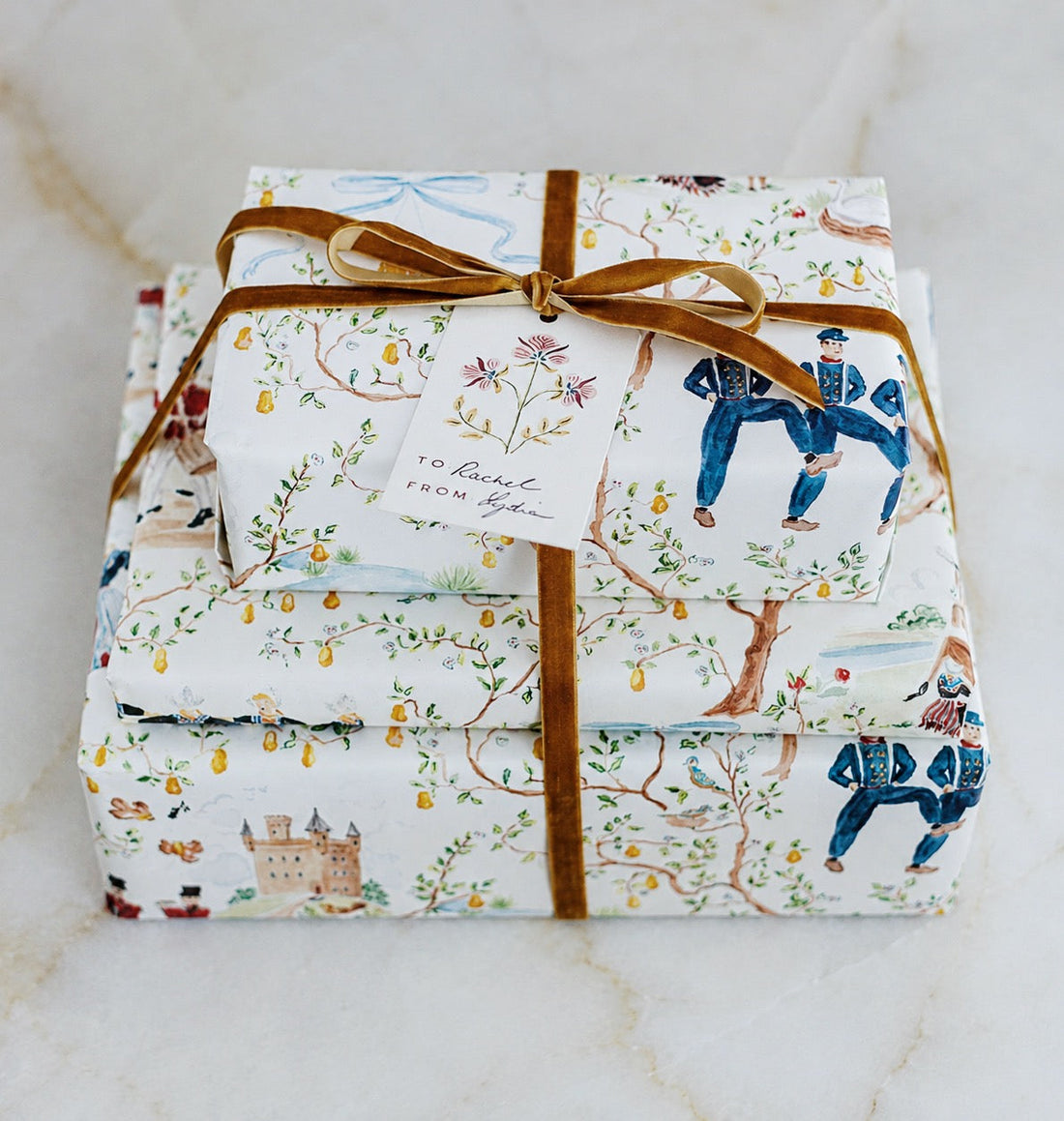 Two beautifully wrapped gifts in illustrated chinoiserie wrapping paper, tied with golden velvet ribbon and a House of Modern Vintage gift tag.