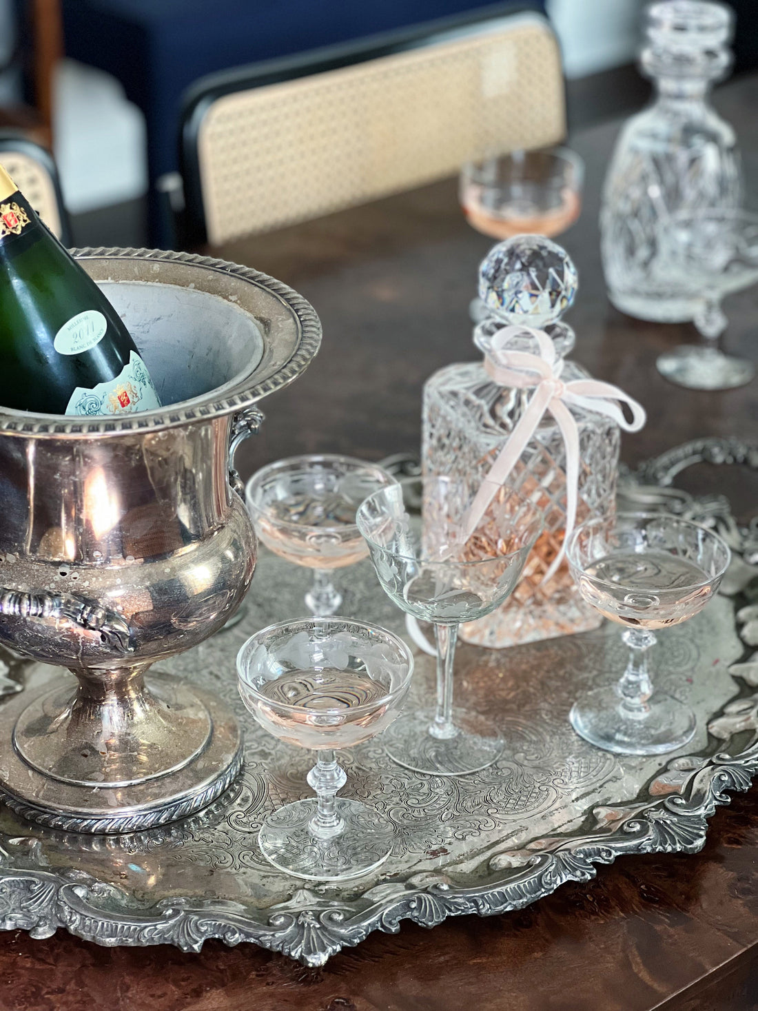 Vintage home bar styled with a silver champagne bucket, crystal decanter, and cocktail glasses