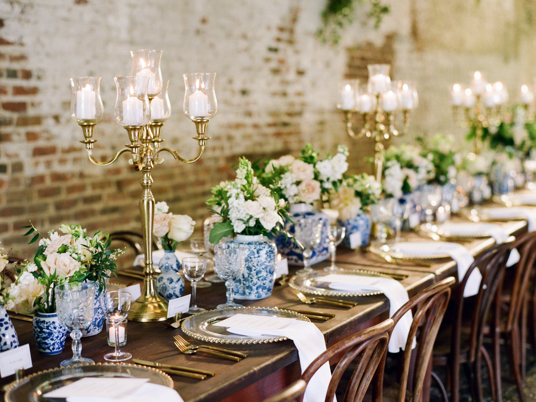 Timeless wedding reception featuring vintage blue and white chinoiserie centerpieces, brass candelabras, antique wood tables, and vintage crystal glassware.