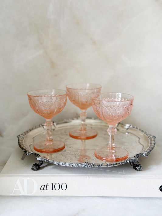 Vintage pink depression glass champagne coupe on an antique serving tray
