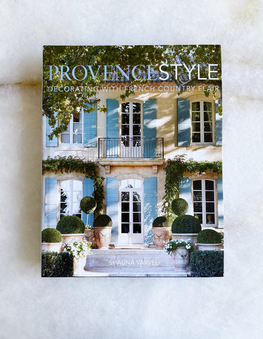 Book titled 'Provençal Style: Decorating with French Country Flair' on a white surface