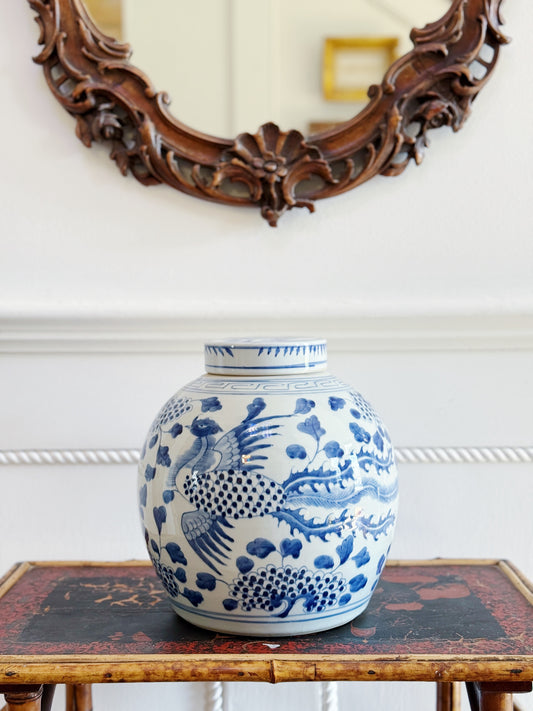 Blue and white hand painted ginger jar with phoenix detailing on vintage furniture 
