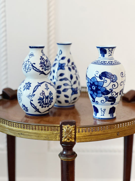 trio of blue and white bud vases on wooden table