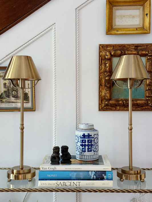 Pair of  Brass Buffet Lamps on a console with vintage coffee table books and blue and white chinoiserie 