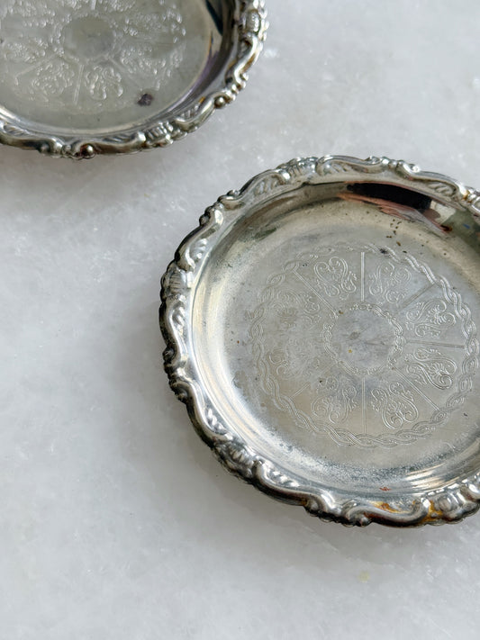 Etched design on a set of vintage silver wine coasters.   