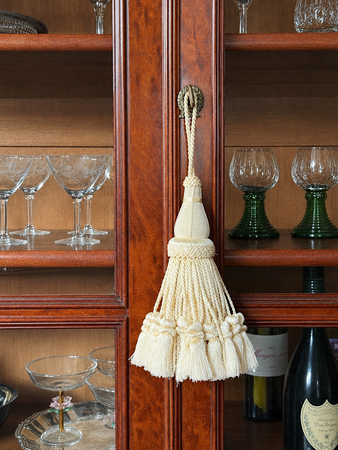 Ivory Decorative Tassel Shown on an antique glass front cabinet