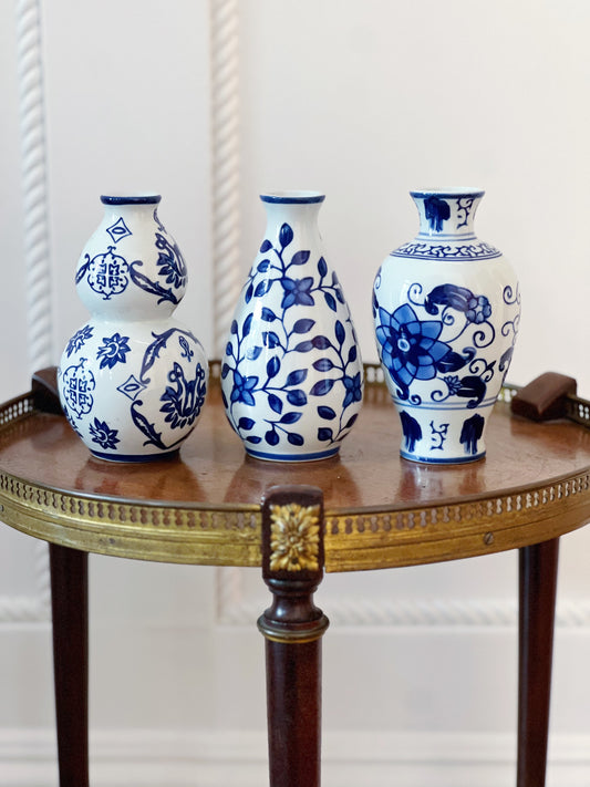 trio of blue and white bud vases on wooden table