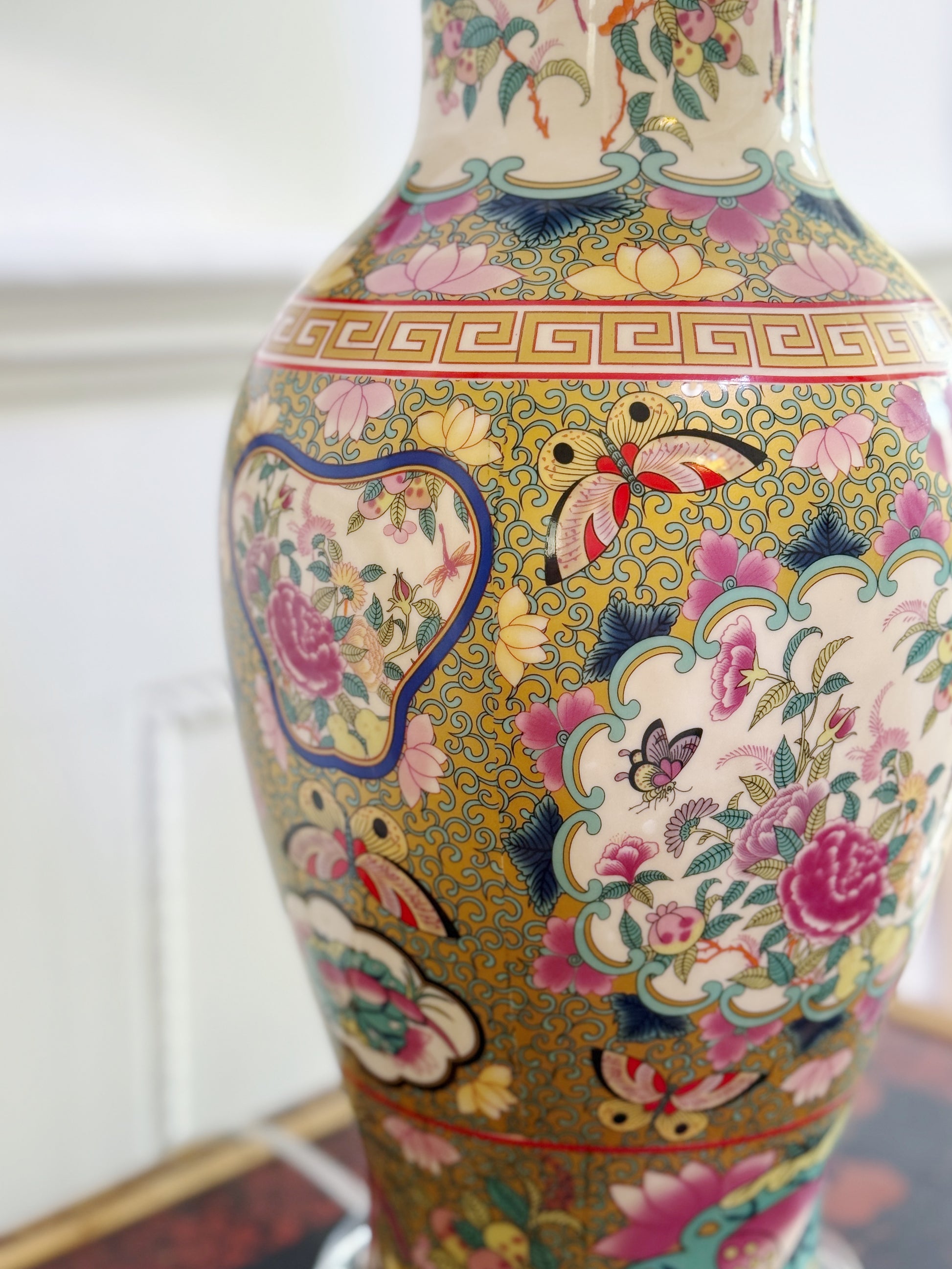 Decorative vase with floral and butterfly patterns on a white background