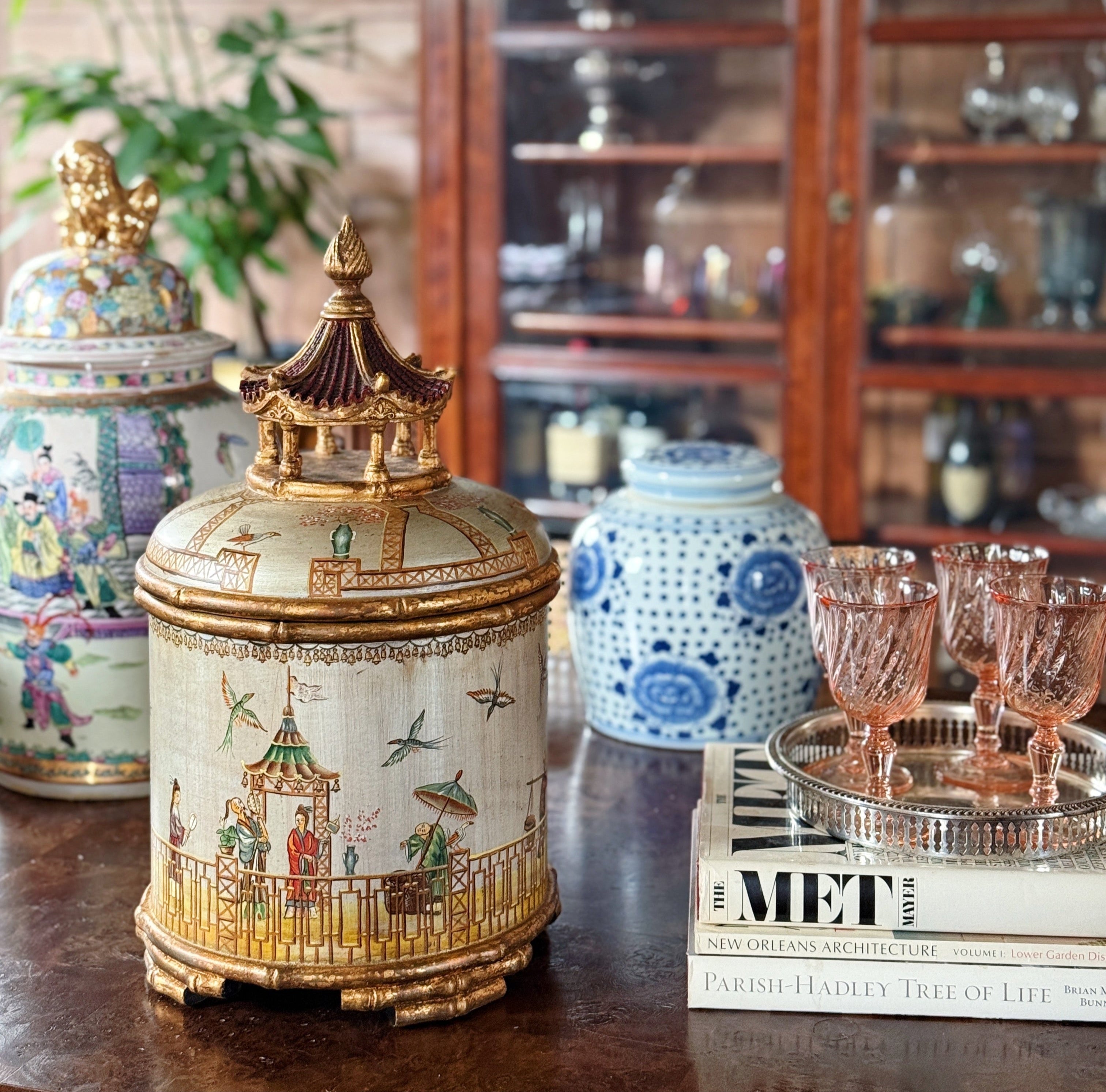vintage chinoiserie pagoda jar with gilt detailing, surrounded by ecclectic famille rose and blue and white ginger jars styled on a dark table, by House of Modern Vintage 