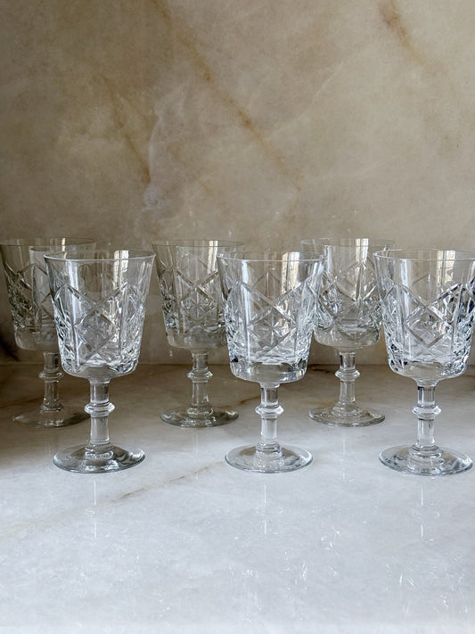 Six vintage glass starburst wine goblets lined up