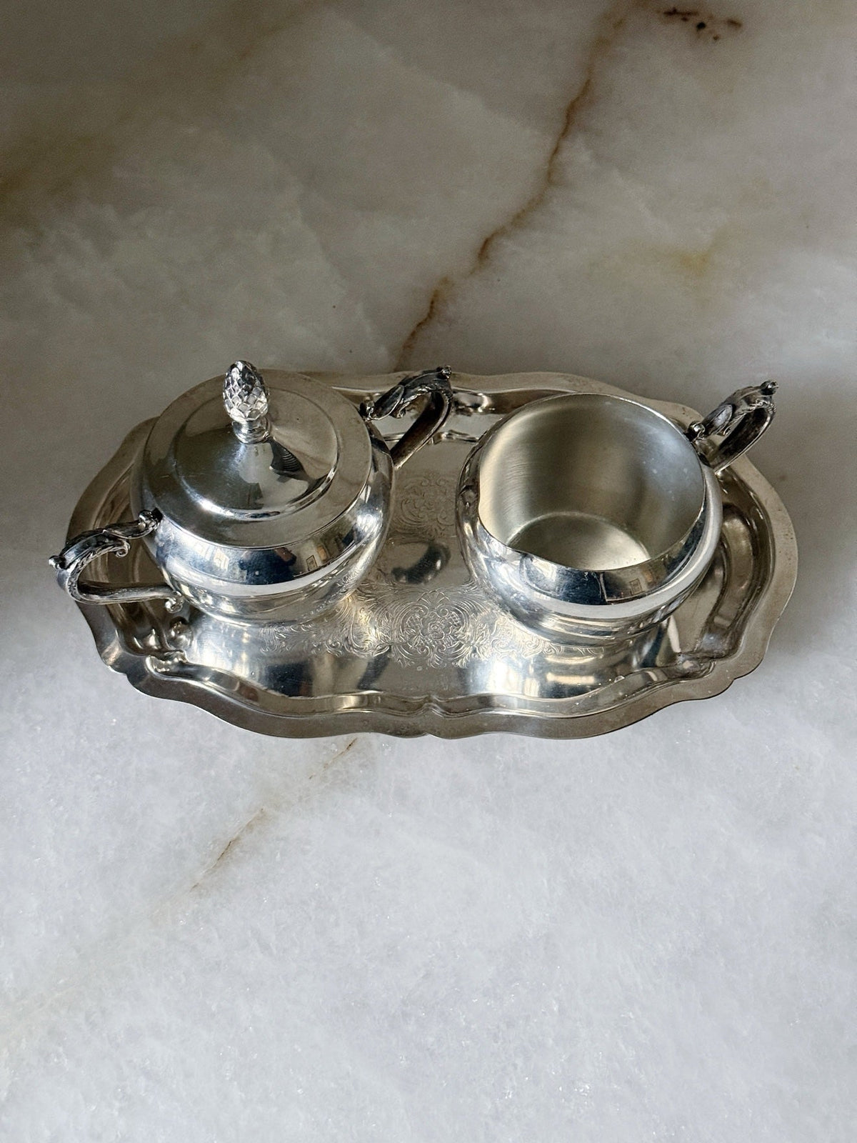 Overhead view of the vintage silverplate sugar bowl, creamer, and etched tray