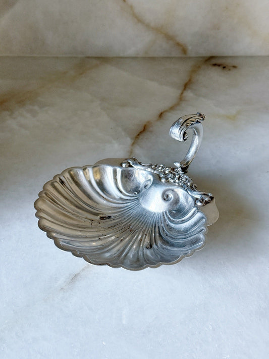 Vintage silver shell dish with ornate floral handle, front view