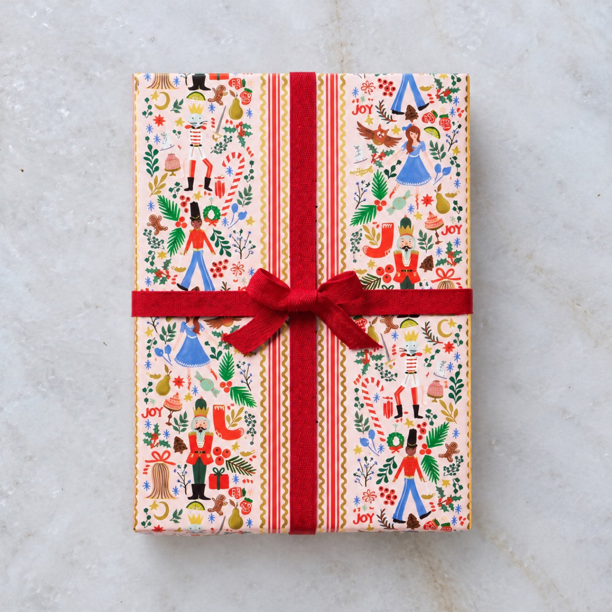 Holly Jolly Nutcracker wrapping paper on a gift with red ribbon