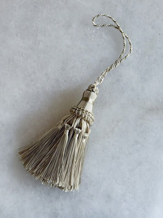 Natural decorative tassel hanging on a marble background